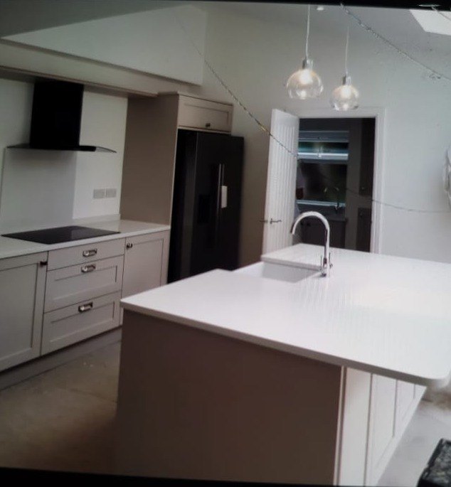 Finished kitchen in a new extension with an island, sink and pendant lights