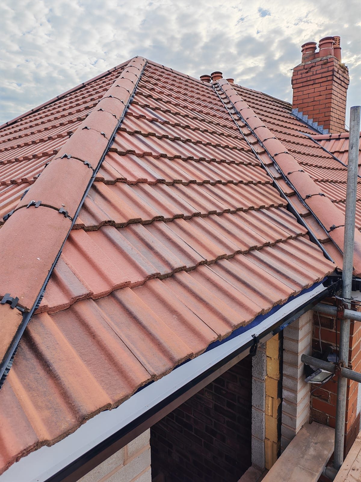 New hipped roof tiled out over a side extension with the scaffold still up